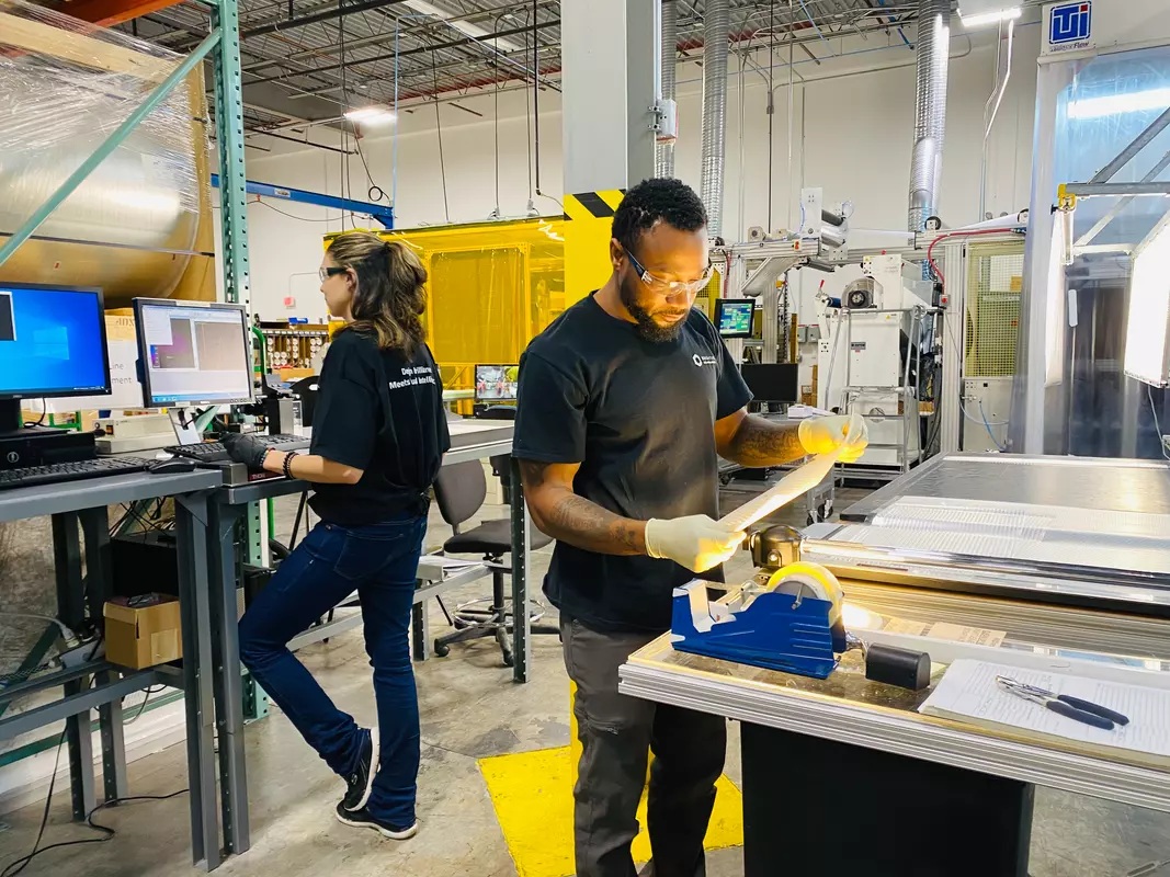 Manufacturing workers using production equipment and computer controls